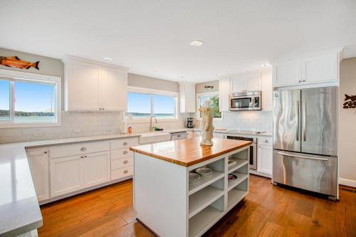 a kitchen with white cabinets and a wooden counter top at Sound of Sight in Allyn