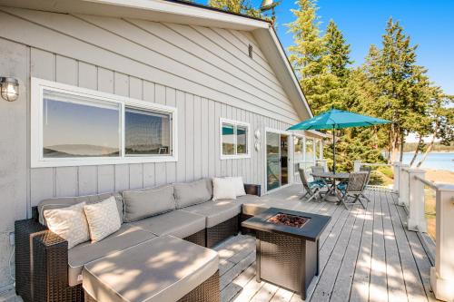 a patio with a couch and a table and an umbrella at Sound of Sight in Allyn