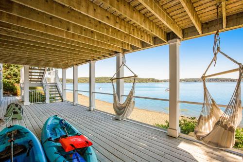 a porch with two kayaks and hammocks and a view of the water at Sound of Sight in Allyn