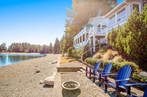 a row of blue chairs on a beach next to a building at Sound of Sight in Allyn