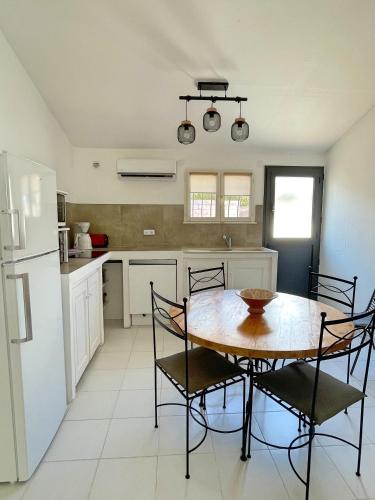 a kitchen with a table and chairs and a refrigerator at Résidence Storia di Blue in Porto-Vecchio