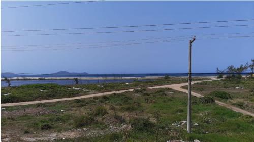 un camino de tierra con un poste en un campo en Arraial do Cabo – Subuai Village - Aluguel Econômico, en Arraial do Cabo