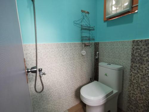 a bathroom with a toilet and a blue ceiling at EZ & V Guesthouse in Pagsanjan