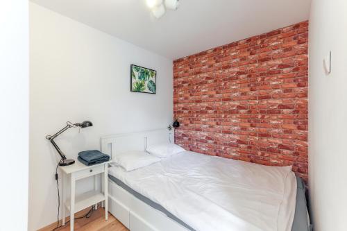 a bedroom with a brick wall and a bed at Centrum Gdańsk blisko Starówki in Gdańsk