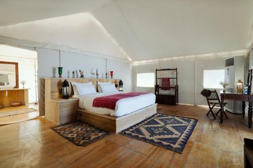 a bedroom with a bed and a desk in a tent at The Kafila Desert Camp in Sām