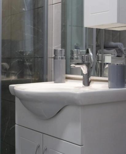 a white sink in a bathroom with a mirror at Apartman Amor Trebinje in Trebinje