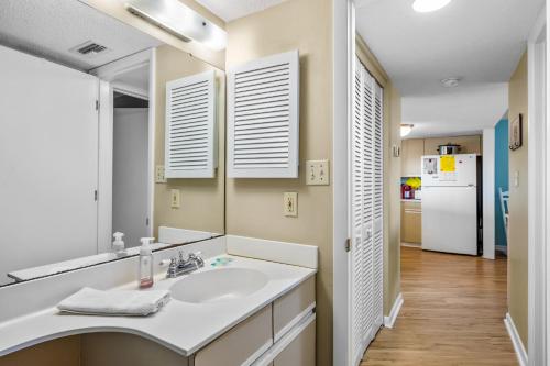 a bathroom with a sink and a refrigerator at Sands Villa 216 in Atlantic Beach