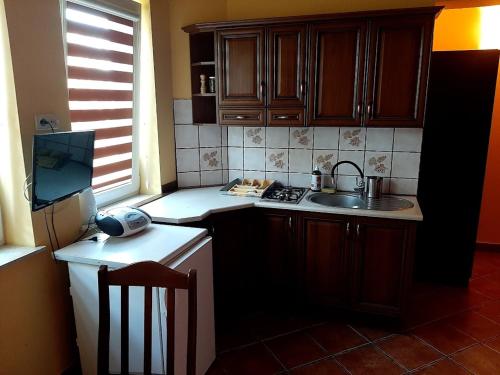 a kitchen with wooden cabinets and a sink and a stove at Pokoje u Gruszki in Swarzewo