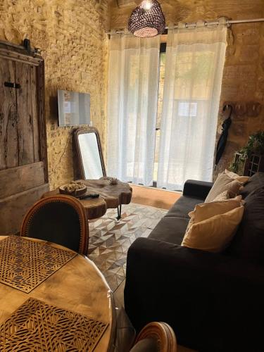 a living room with a couch and a table at Gîte le médiéval in Sarlat-la-Canéda