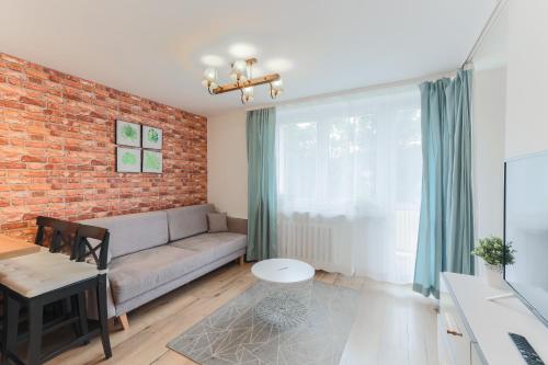 a living room with a couch and a brick wall at Centrum Gdańsk blisko Starówki in Gdańsk
