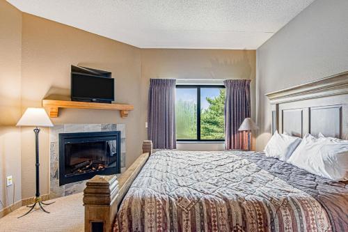 a bedroom with a bed with a fireplace and a television at Chula Vista Condo Unit 2645 in Wisconsin Dells
