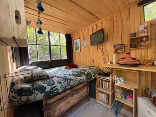 une chambre avec un lit dans une cabane en bois dans l'établissement Ironvan, à Bernac