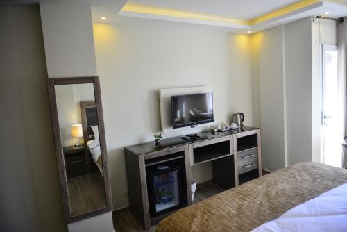 Schlafzimmer mit einem TV, einem Bett und einem Spiegel in der Unterkunft Moses Residence in Wadi Musa