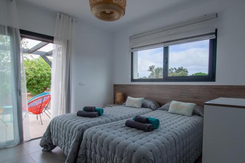 a bedroom with two beds and a large window at Villa Wind Wave 28A Heated & Shared Pool in Lajares