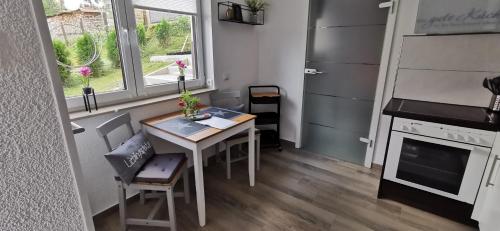 una pequeña cocina con mesa y ventana en Ferienwohnung Tannenzwerg, en Tannenberg