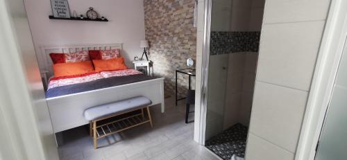 Dormitorio pequeño con cama con almohadas de color naranja en Ferienwohnung Tannenzwerg, en Tannenberg