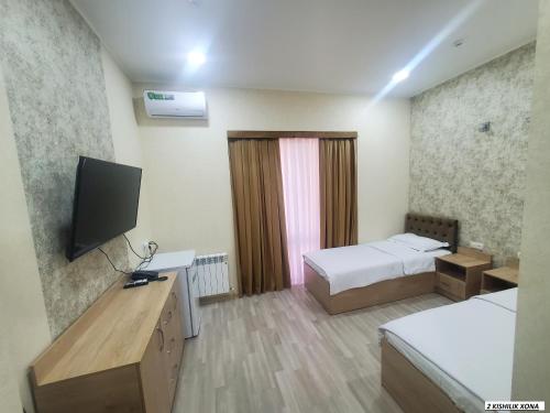 a room with two beds and a television in it at MAZZA Hotel in Tashkent