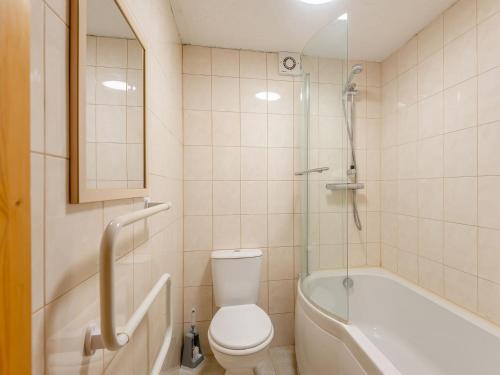 y baño con aseo, bañera y ducha. en Robins Nest - Uk36208, en Llanfihangel-y-creuddyn