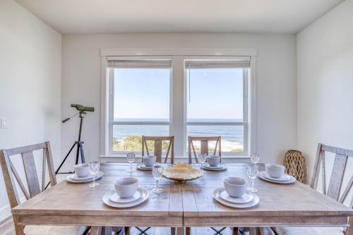 a dining room with a table with chairs and a view of the ocean at Lincoln Landing in Lincoln City