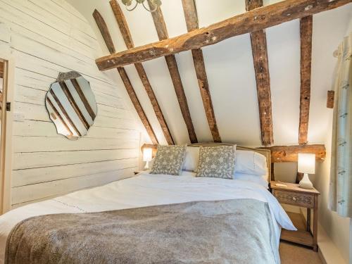 a bed in a room with wooden beams at The Cottage in Warborough