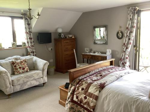 a bedroom with a bed and a chair and a desk at Bosvean House Bed & Breakfast in Bude