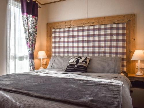Schlafzimmer mit einem großen Bett mit einem Kopfteil aus Holz in der Unterkunft Everard - Uk37772 in Stoupe Brow