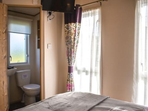 ein Schlafzimmer mit einem Bett, einem WC und einem Fenster in der Unterkunft Everard - Uk37772 in Stoupe Brow