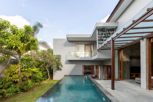 a house with a swimming pool in front of it at SooBali Niscala Villa 5 Bedroom in Canggu