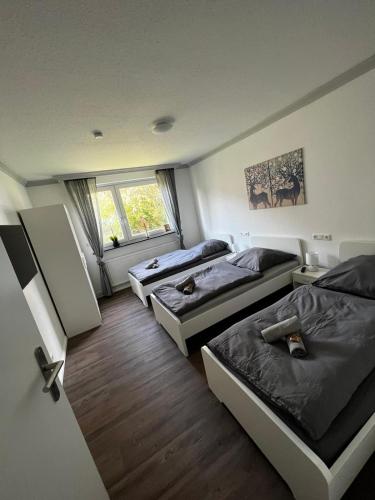 a bedroom with three beds and a window at Ferienwohnung Carlos 1 und 2 in Bad Harzburg