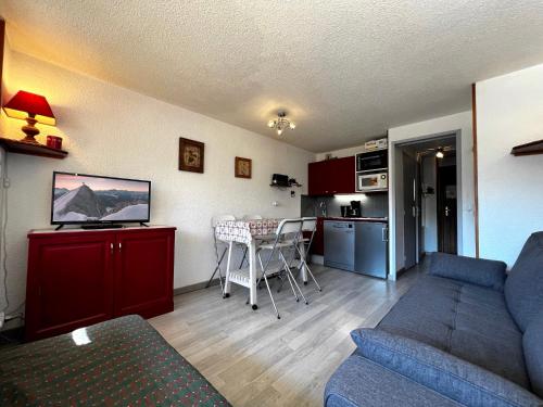 un salon avec un canapé et une cuisine dans l'établissement Alcyon A23 - Studio proche pistes, à La Clusaz