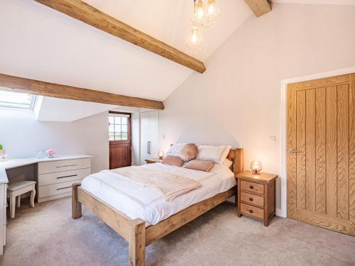 a bedroom with a bed and a desk and a sink at Stuarts Farm Barn in Westhead