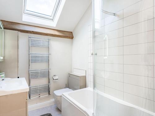 La salle de bains est pourvue de toilettes, d'un lavabo et d'une douche. dans l'établissement Stuarts Farm Barn, à Westhead