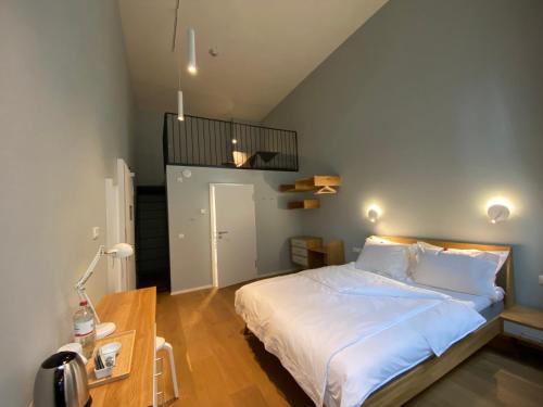 Un dormitorio con una gran cama blanca y una mesa en The Layhead B&B en Lübeck