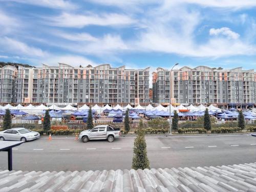 a parking lot with cars parked in front of a large building at Golden Sweet Home @ CH Golden Hills (Night Market) in Cameron Highlands