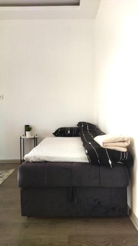 a bed sitting in a room with a wall at Home Mia Airport in Podgorica