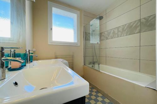 baño con lavabo, bañera y ventana en Beautiful 1950s style apartment close to the city center en Tours