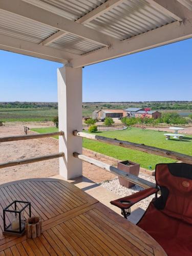 a patio with a table and a chair on a deck at Sterrenhemel Guest Farm in Upington