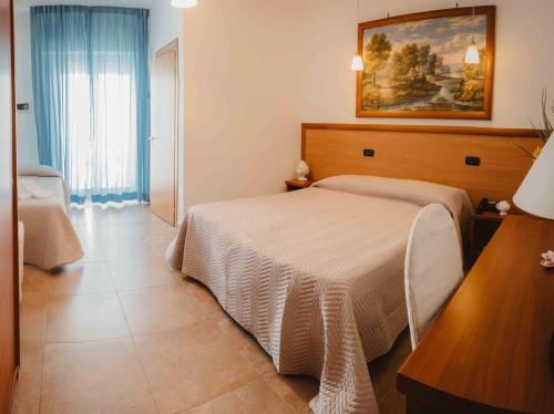 a bedroom with a bed and a painting on the wall at Accord Le Rose in Palagiano
