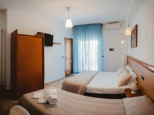 a hotel room with two beds and a television at Accord Le Rose in Palagiano