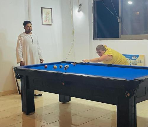 a man and a woman playing a game of pool at El Mesala Hotel in Luxor