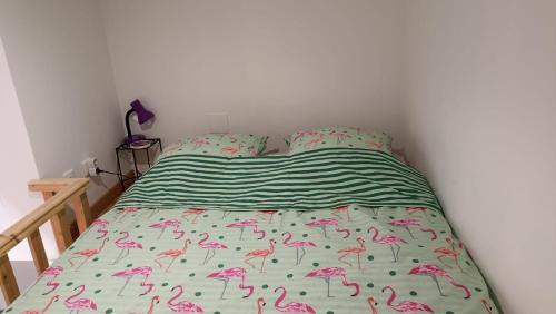 a bed with pink flamingos on it in a bedroom at Escale à Bouzigues in Bouzigues
