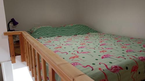 a bed with pink flamingos on it in a bedroom at Escale à Bouzigues in Bouzigues