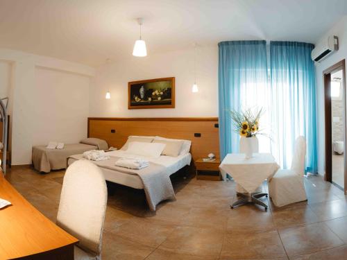 a bedroom with a bed and a table and chairs at Accord Le Rose in Palagiano