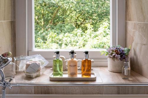 un mostrador con botellas en el alféizar de la ventana en Afon Rhaiadr Country House, en Dolgellau