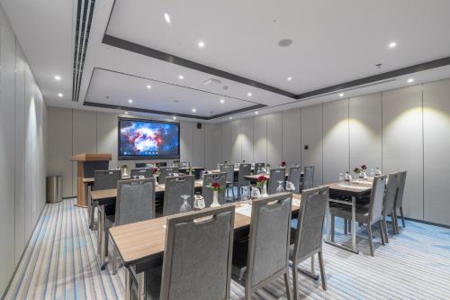 a conference room with tables and chairs and a flat screen tv at Braira Al Yarmouk in Riyadh