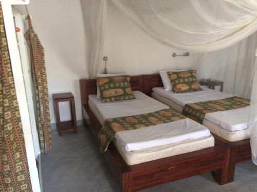 a room with three beds in a room at Casa Fabula in Ilha de Moçambique