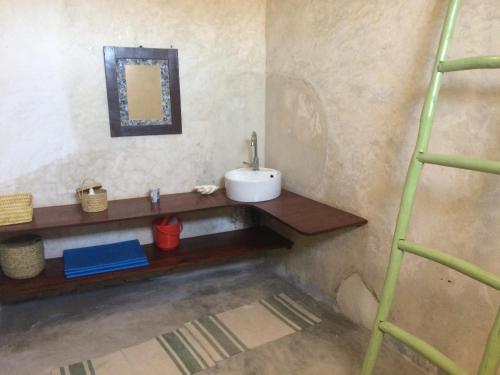 a bathroom with a sink and a shelf in a room at Casa Fabula in Ilha de Moçambique