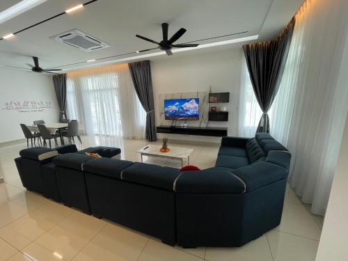 a living room with a blue couch and a table at 家好月圆 Sweet Home in Kampong Seri Gading