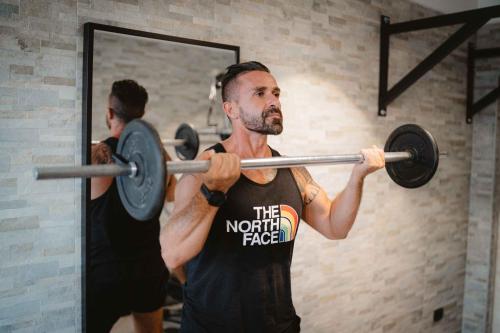 a man lifting a barbell in a gym at Accord Le Rose in Palagiano