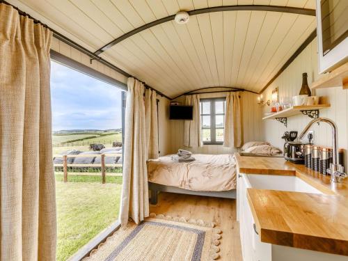 ein Schlafzimmer mit einem Bett und einem großen Fenster in der Unterkunft Daisys Rest in Shipton under Wychwood